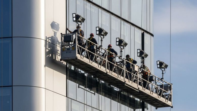 عمال تركيب الواجهات يعملون بأمان على منصة معلقة - تنفيذ الكلادينج والواجهات