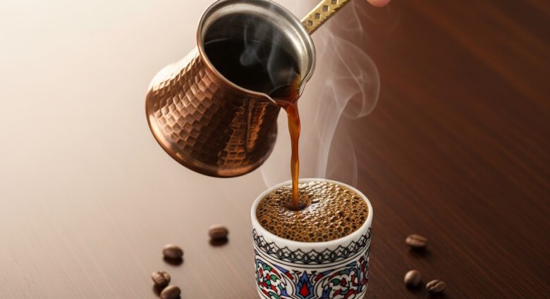 فنجان قهوة تركية بوجه كثيف وركوة نحاسية