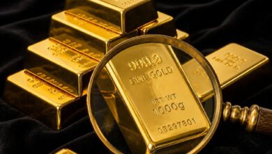 سبائك ذهبية حقيقية مع عدسة مكبرة تظهر دمغة الذهب عيار 24 قيراط بدقة عالية